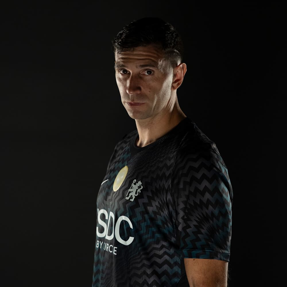 Emiliano Martínez poses in Chelsea's goalkeeper shirt after signing for the club