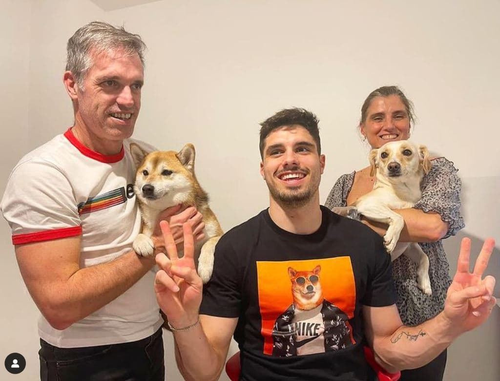 Pedro Neto poses at home with his mother, father and two dogs