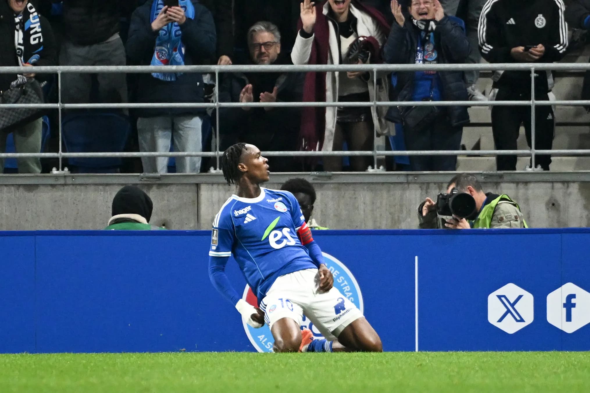 Emanuel Emegha slides in celebration after scoring for Strasbourg against Lille