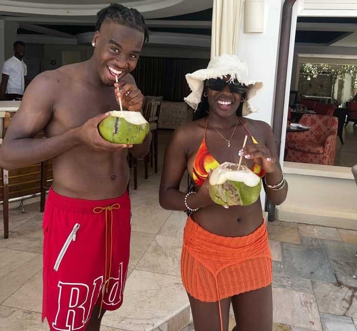 Jamie Gittens drinks from a coconut beside his older sister Chante on holiday